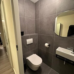 Renovatie tot een moderne badkamer in grijs, zwart en wit 08